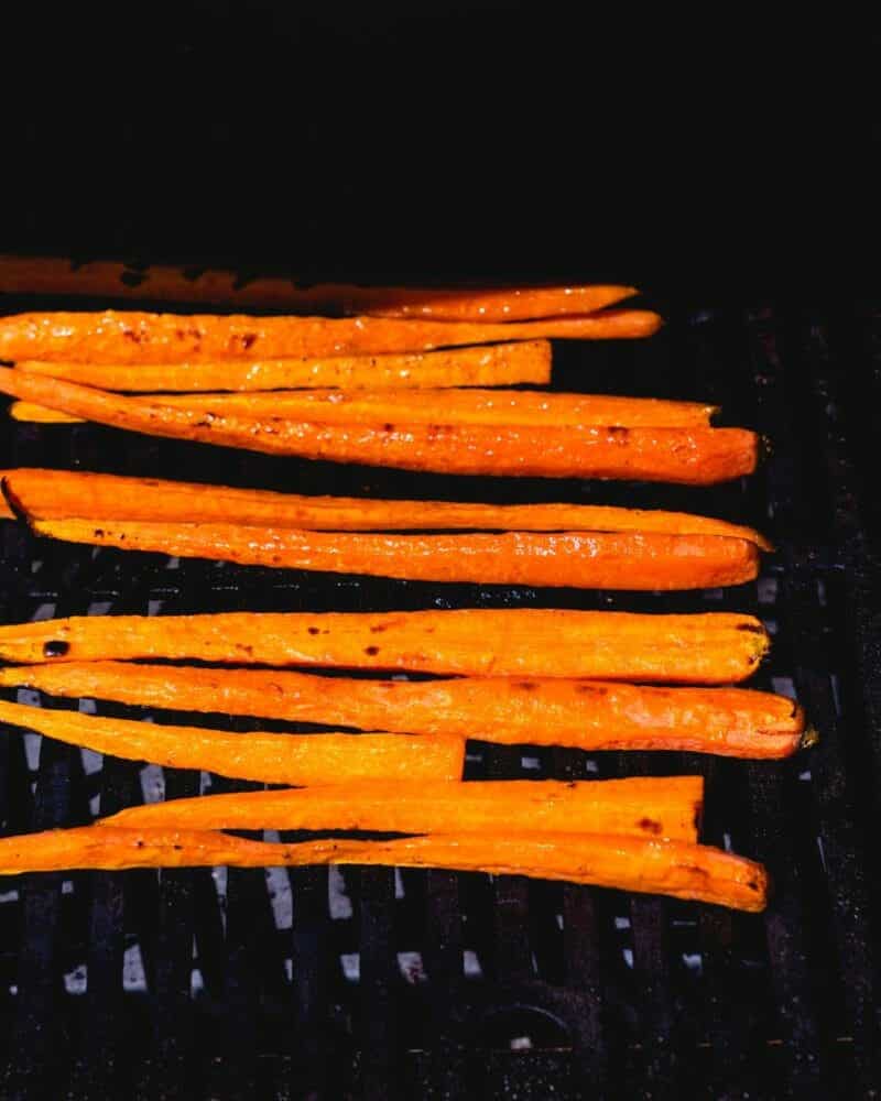 Grilled carrots lined up on a grill