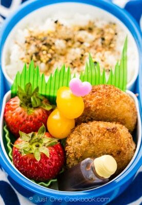 Korokke Bento with rice, tomatoes and fruit.