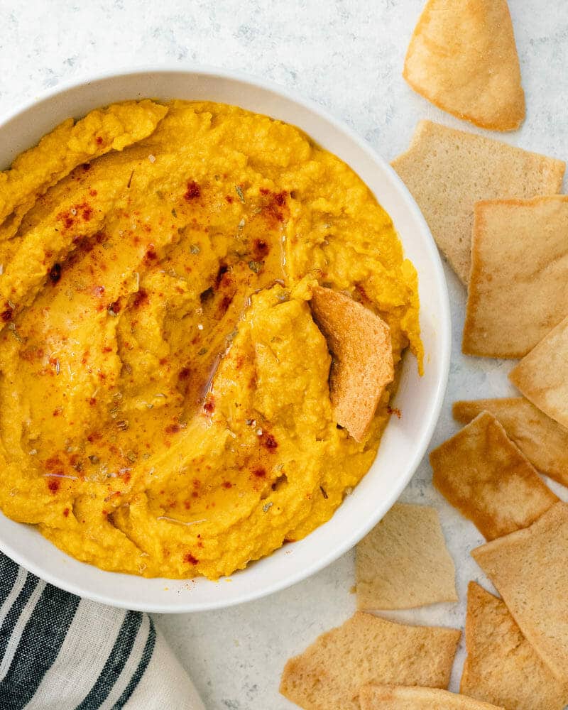 Pumpkin hummus in a bowl served with pita chips