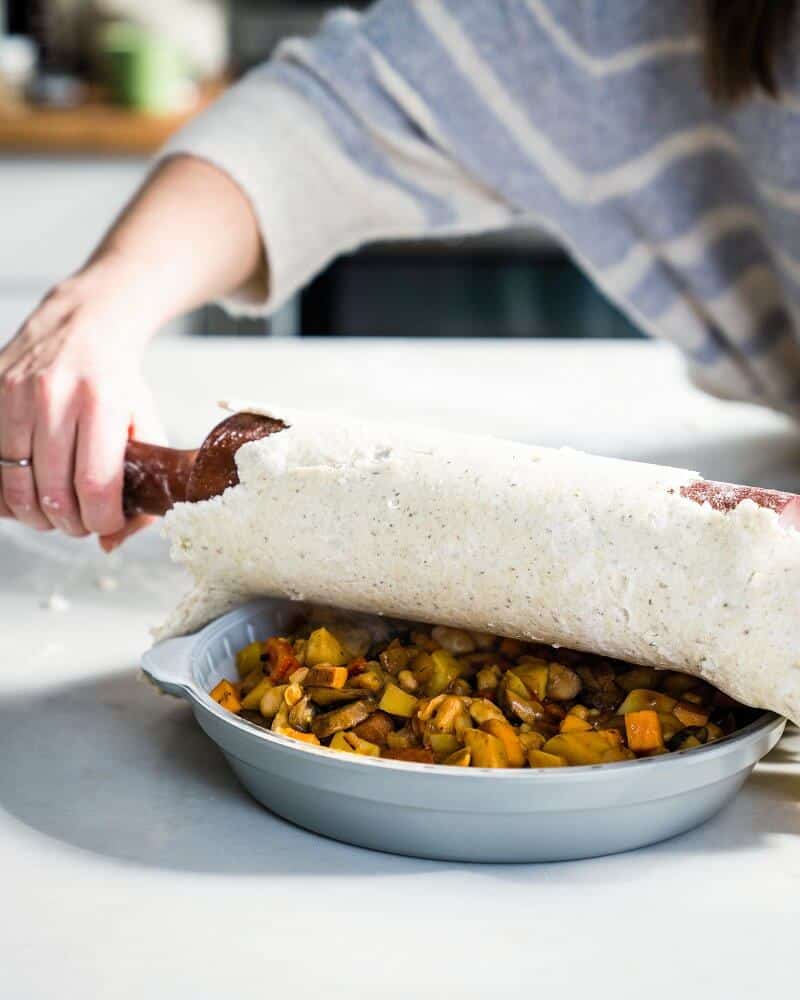 rolling a crust onto a vegan pot pie 