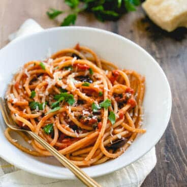 homemade pasta puttanesca in white bowl