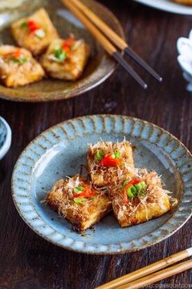 Three pieces of Teriyaki Tofu are placed on a Japanese blue plate | Easy. Japanese Recipes at fancyfoodsshow.com