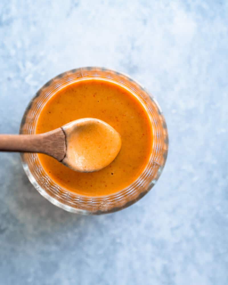 spicy tahini sauce in glass dish with spoon