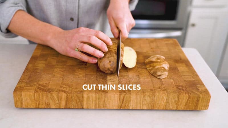 A woman is cutting more thin slices into a potato on a cutting board. It says, "Cut thin slices."