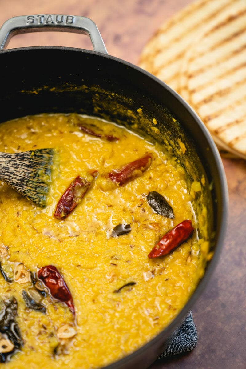 Masoor dal in a saucepan with a wooden spoon dipped in