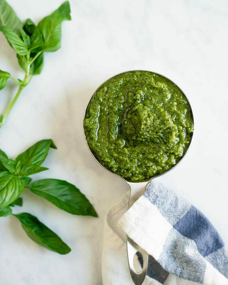 Basil pesto in measuring cup. 