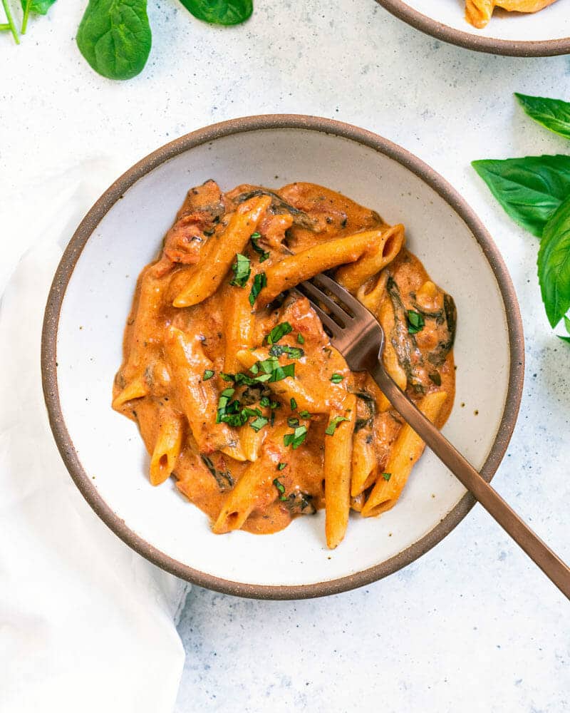 Creamy instant pot pasta garnished with basil leaves