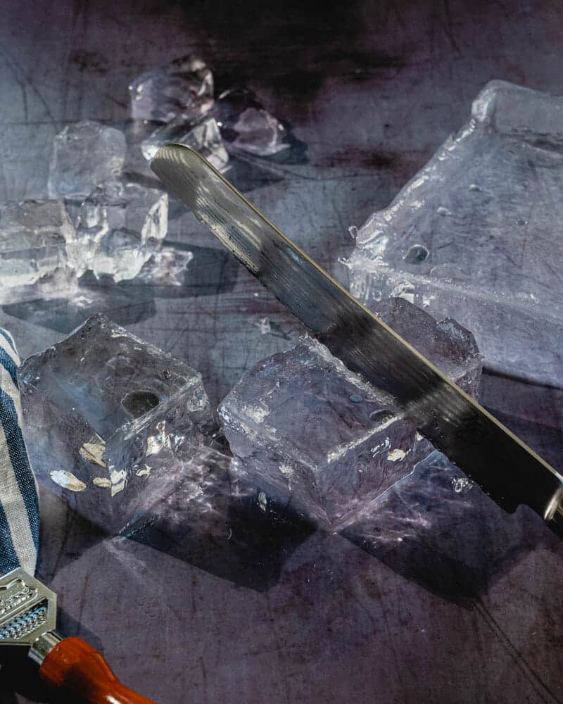Clear ice being cut with a serrated knife