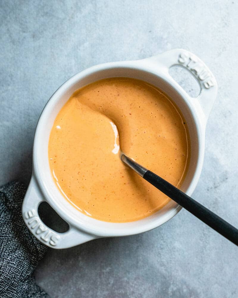 Spicy mayo in a white bowl with a spoon in it