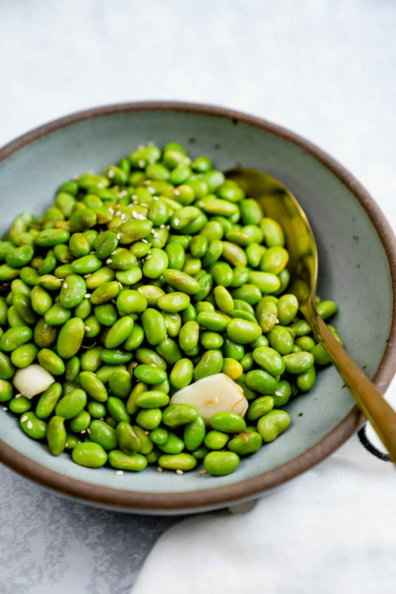 Shelled edamame in a bowl with a spoon