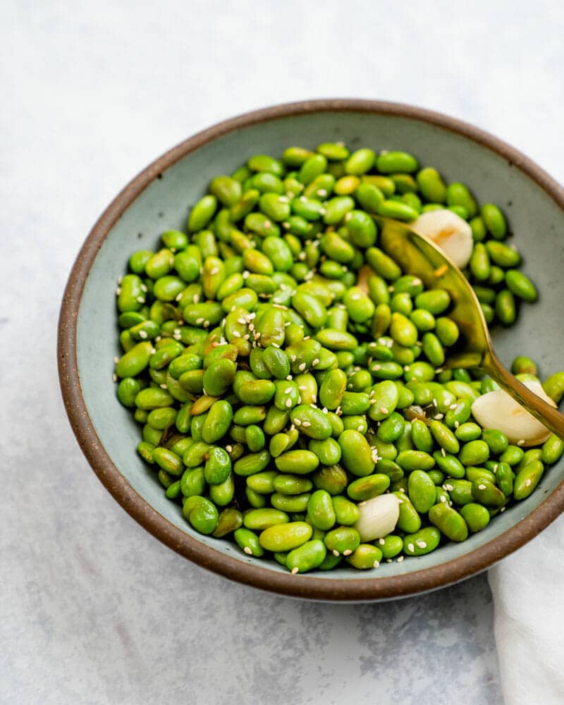 Shelled edamame in a bowl with a spoon