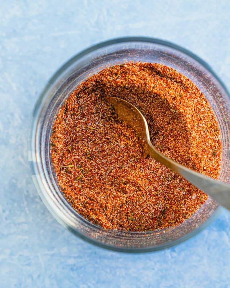 Seafood seasoning in a glass jar with a spoon