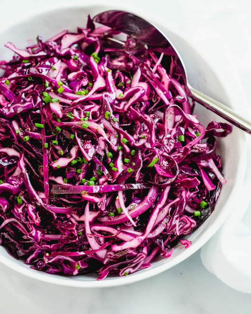 Red cabbage slaw in bowl with spoon
