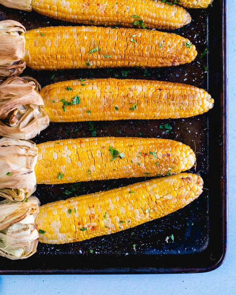 Smoked corn on the cob lined up on a tray