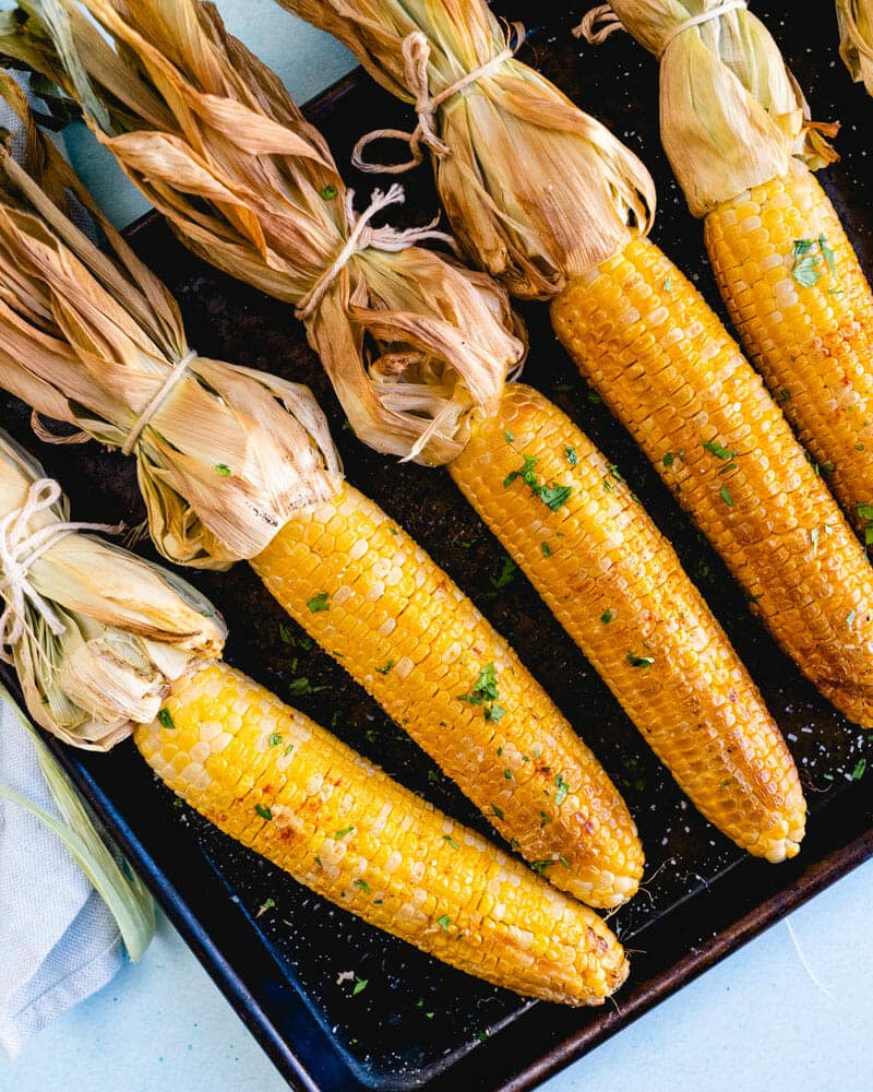 Smoked corn on the cob lined up on a tray