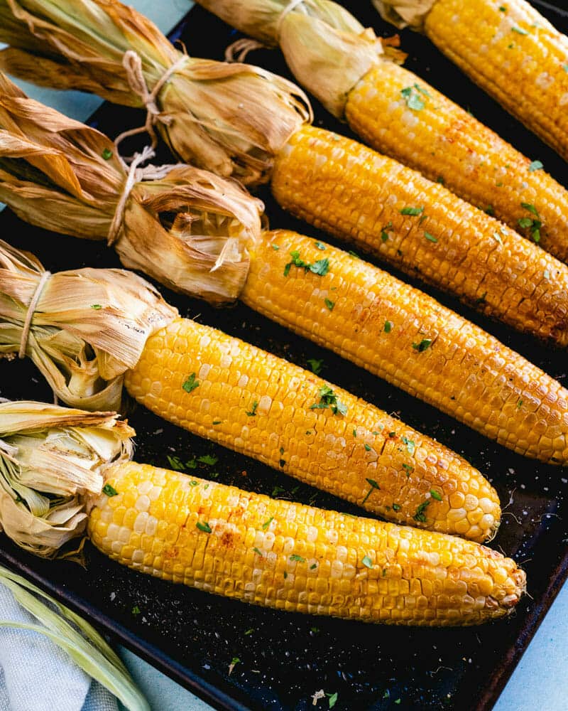 Smoked corn on the cob lined up on a tray