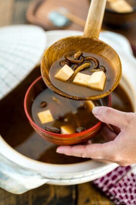 Nameko Miso Soup being served fro a donabe to a wooden bowl.
