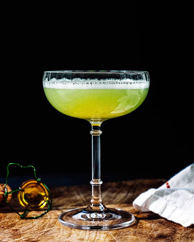 Death in the afternoon cocktail in a tall glass with a dark background