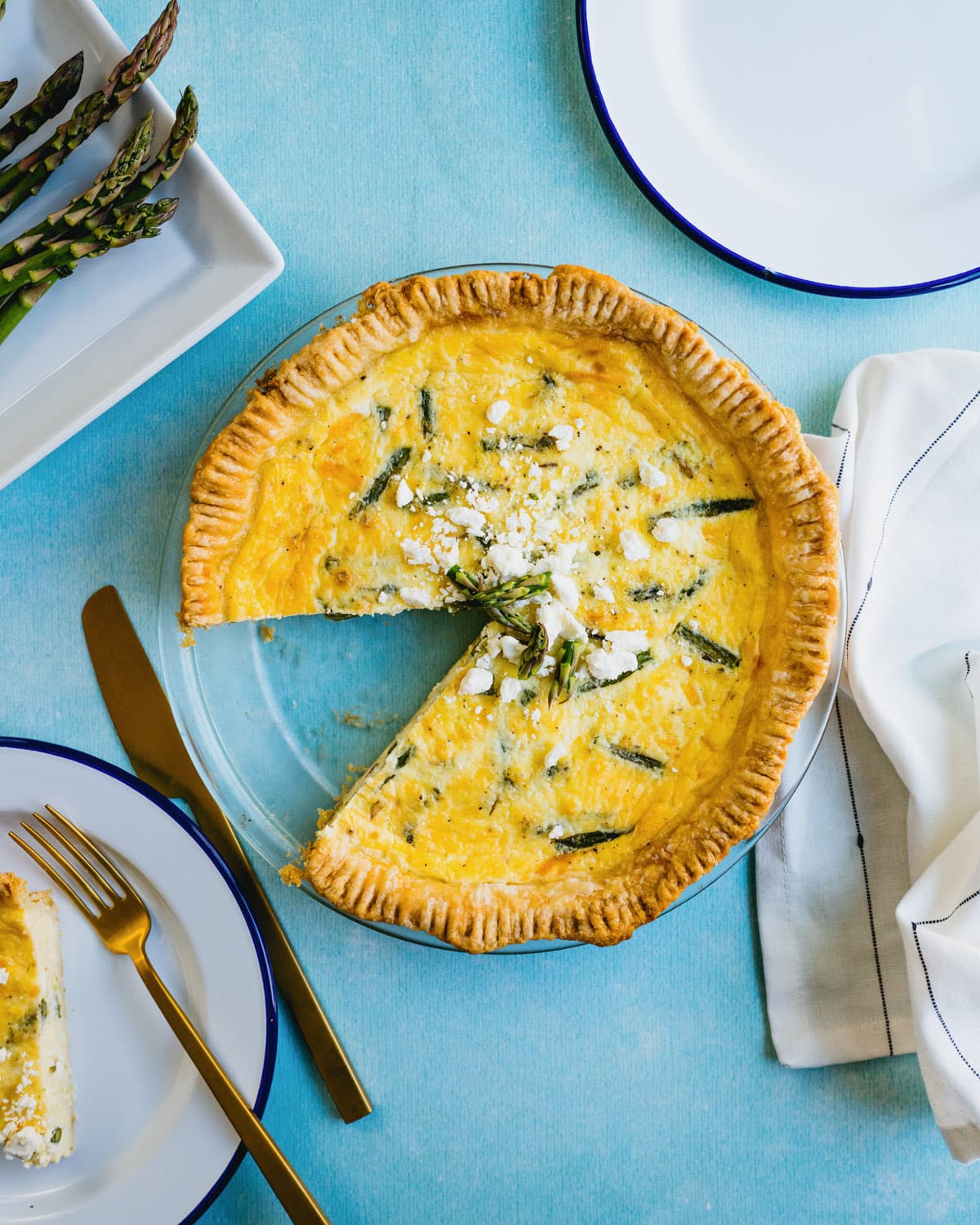 Asparagus Quiche with slice out and table setting.