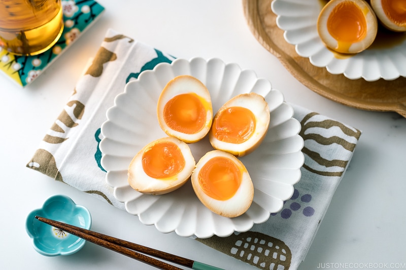 A white ceramic plate containing ramen eggs.