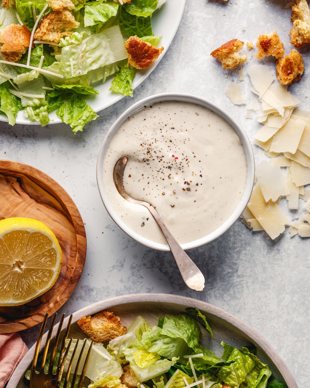 Homemade Caesar salad dressing recipe in bowl with spoon.