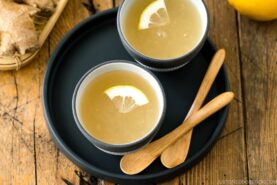 Ceramic cups containing Japanese Ginger Tea (Shogayu) garnished with a slice of lemon.
