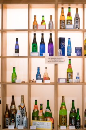 bottles of sake on wooden shelves