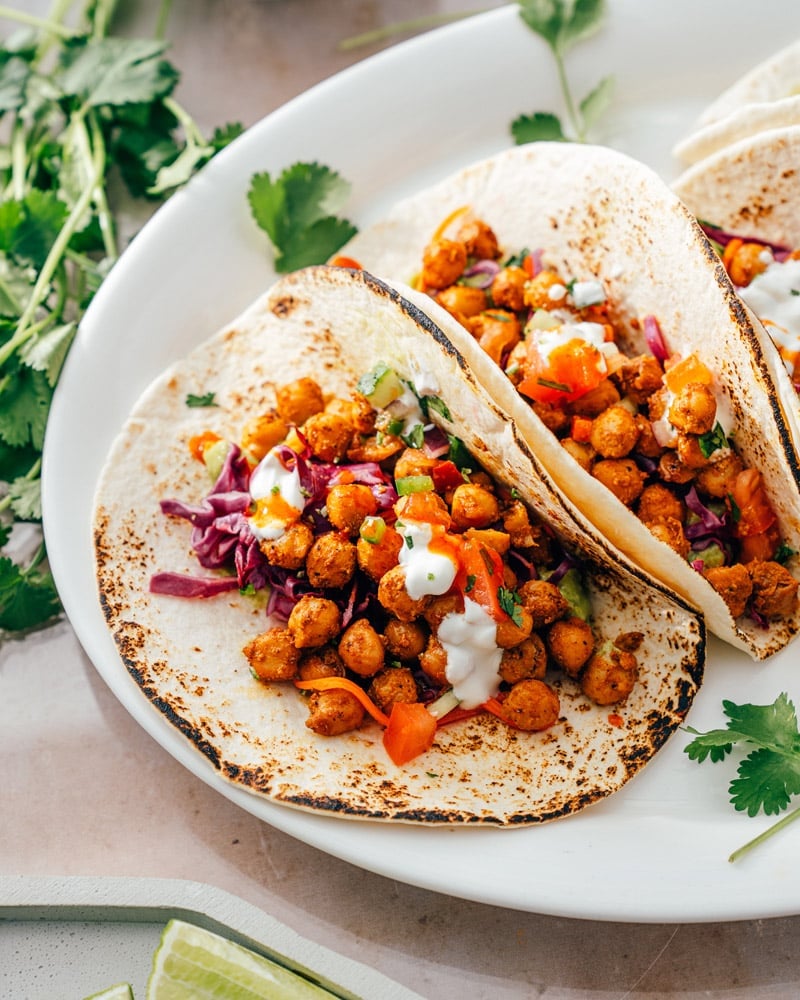 Two chickpea tacos in tortillas with slaw and pico 