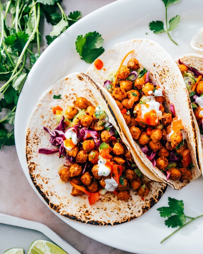 Three chickpea tacos in tortillas with slaw and pico 