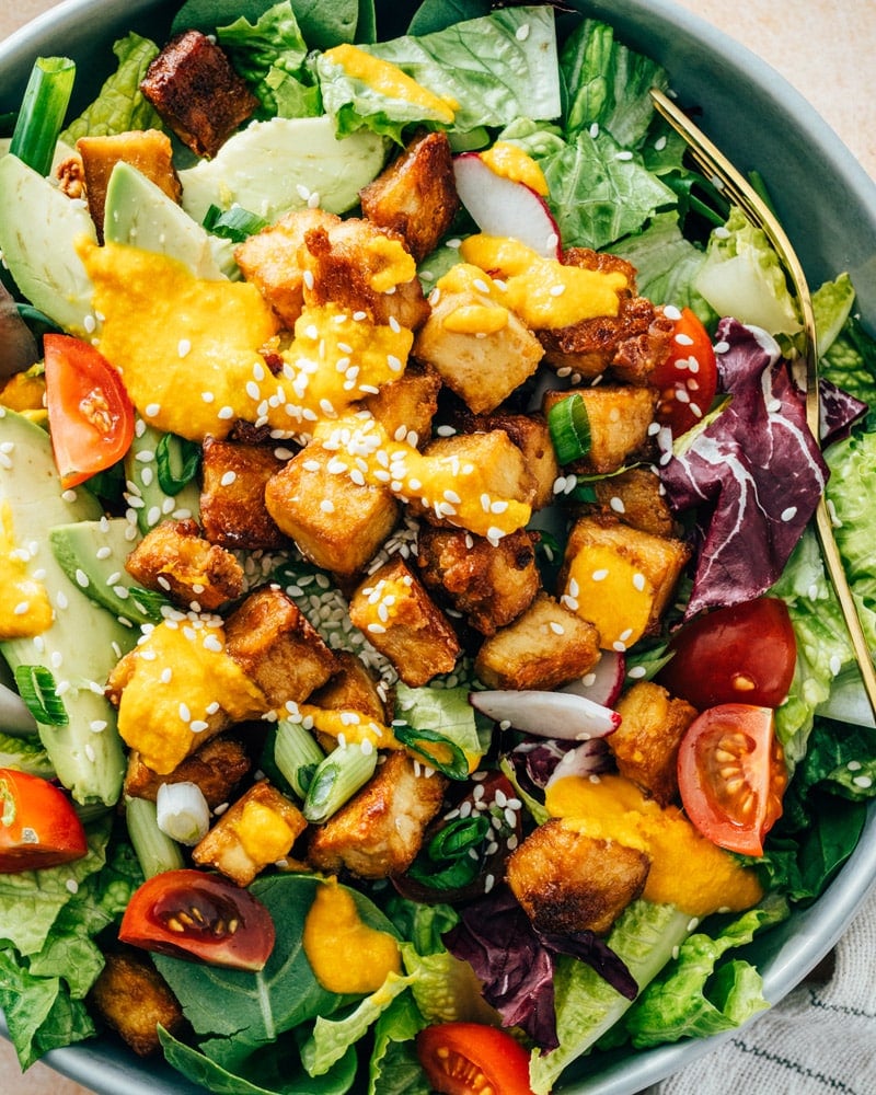Baked tofu on salad with carrot ginger dressing.