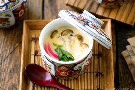 A special Japanese chawanmushi cup containing savory steamed custard filled with kamaboko fish cake, chicken, and mushroom.
