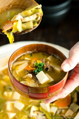 Miso soup served into a soup bowl from a donabe clay pot.