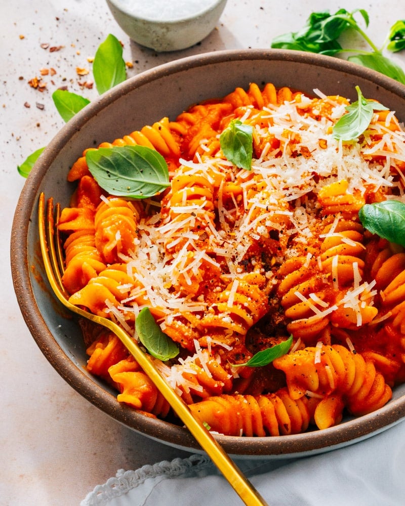 Red Sauce Pasta served in a bowl with a golden spoon and spinkled with parmesan cheese