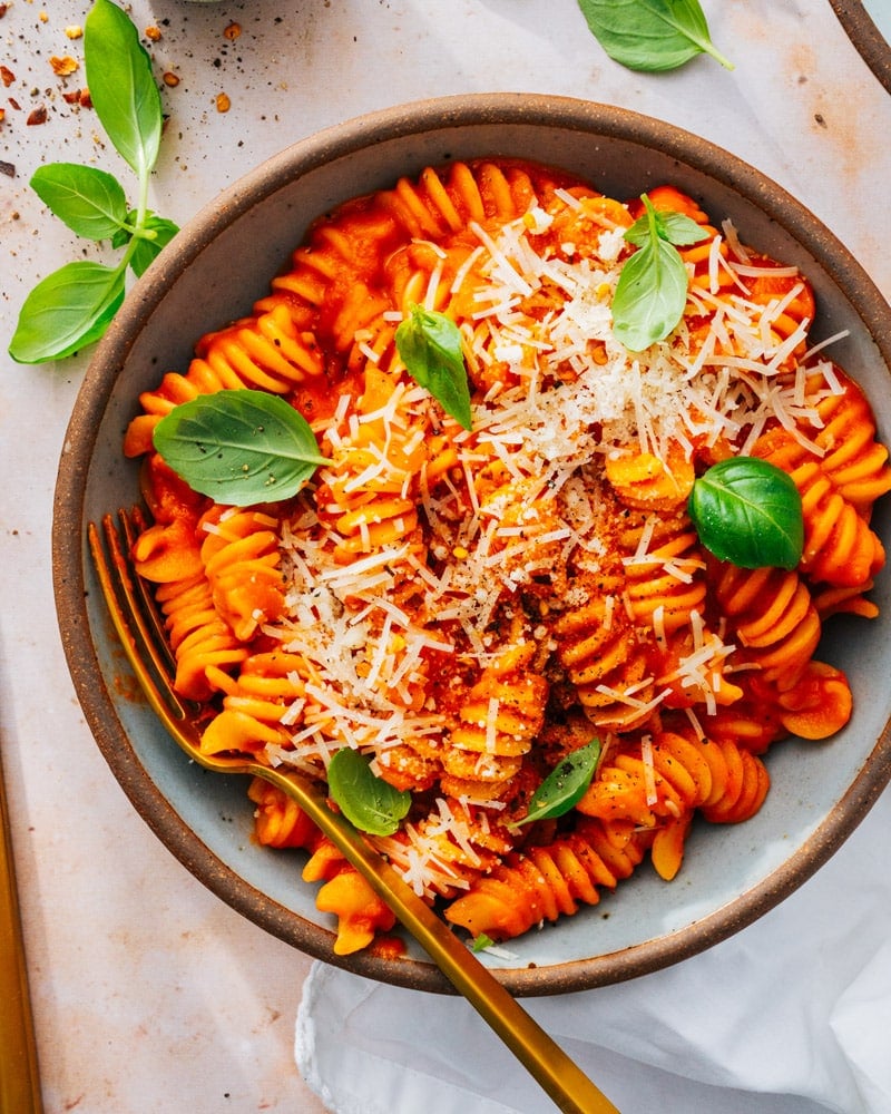 Red Sauce Pasta served in a bowl with a golden spoon and spinkled with parmesan cheese
