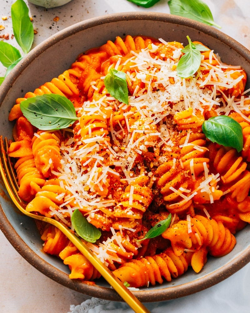 Red Sauce Pasta served in a bowl with a golden spoon and spinkled with parmesan cheese