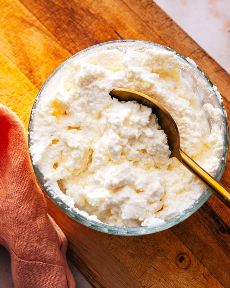 A bowl of ricotta cheese with a spoon