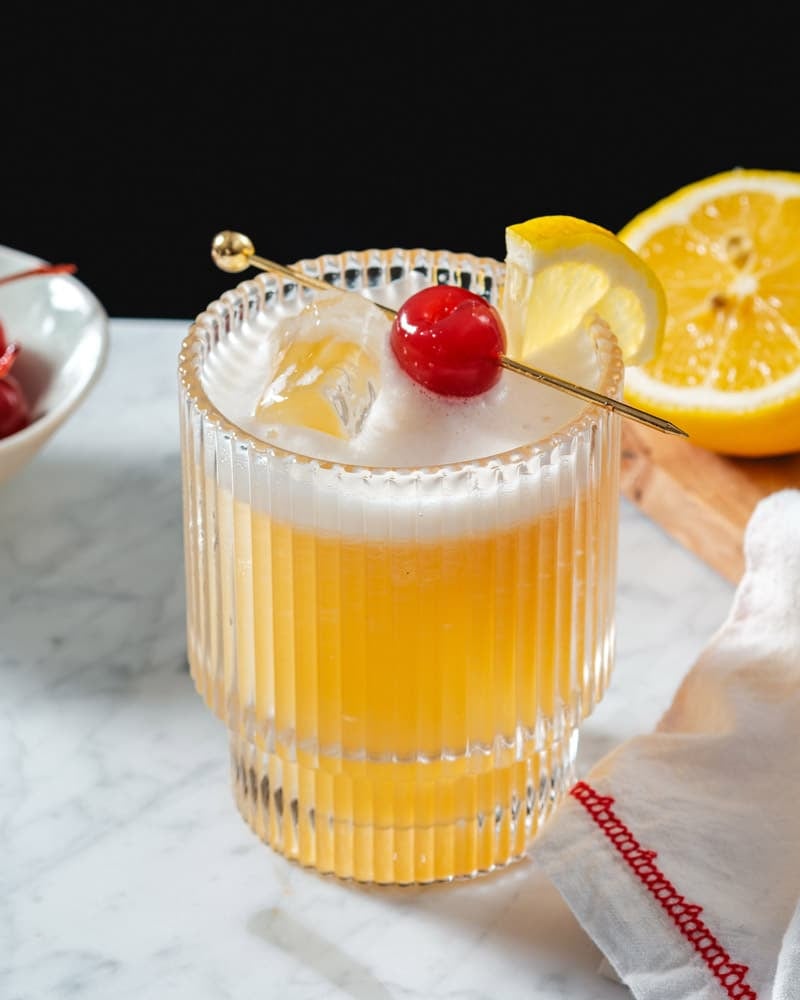 Rum Sour drink in cocktail glass with cherry and lemon garnish