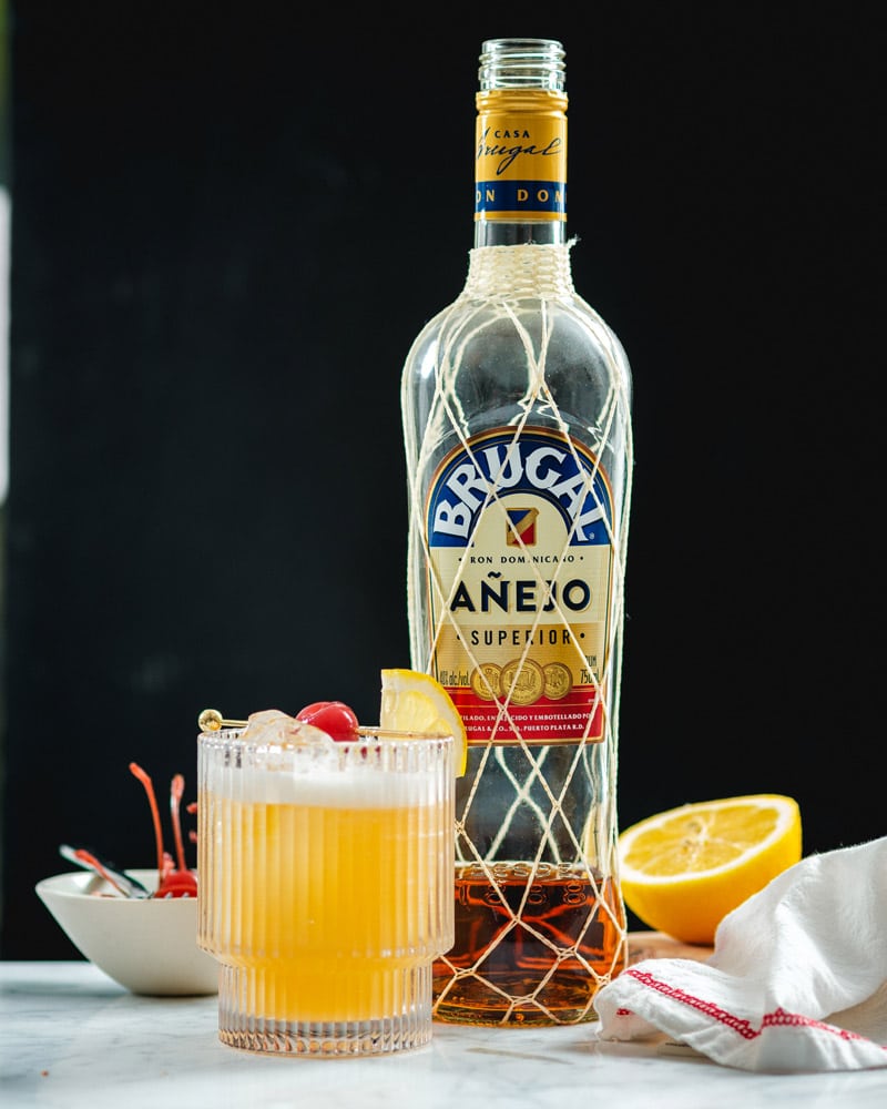 Rum Sour cocktail with rum bottle