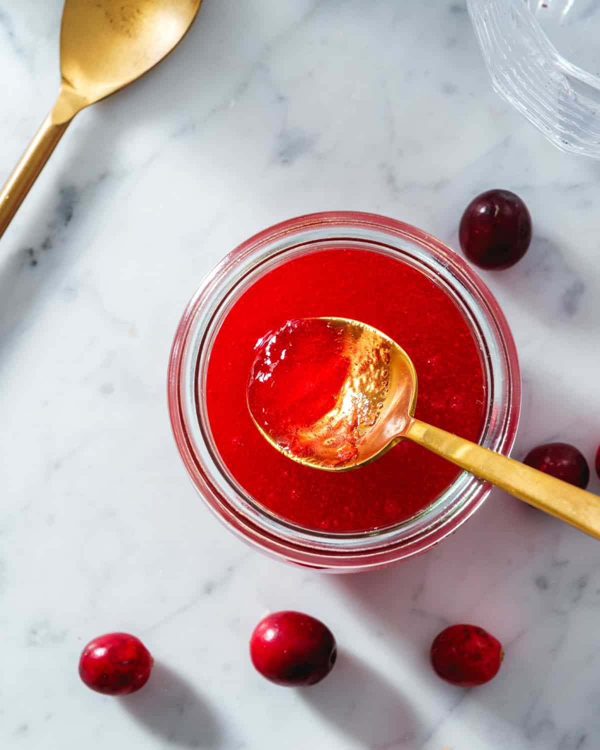 Cranberry Simple Syrup with spoon coming out of jar