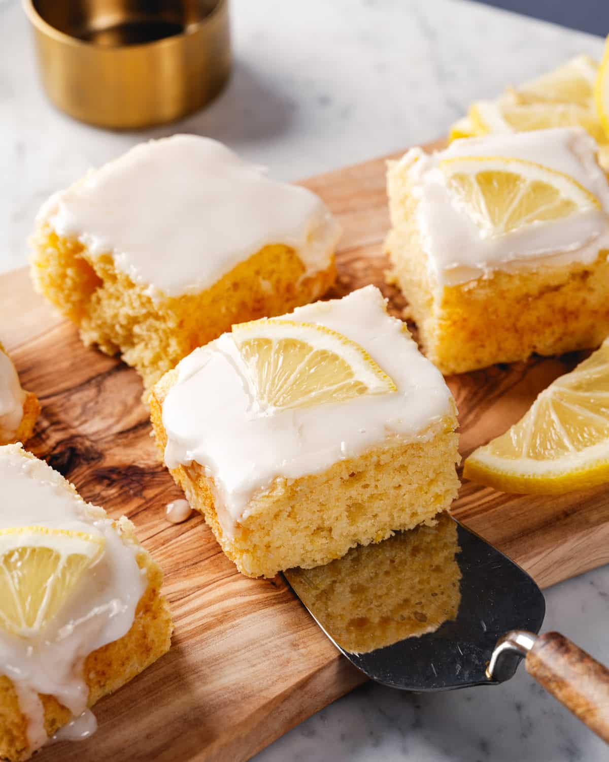Easy Lemon Cake recipe on cake server with lemon glaze and lemon slice garnish.