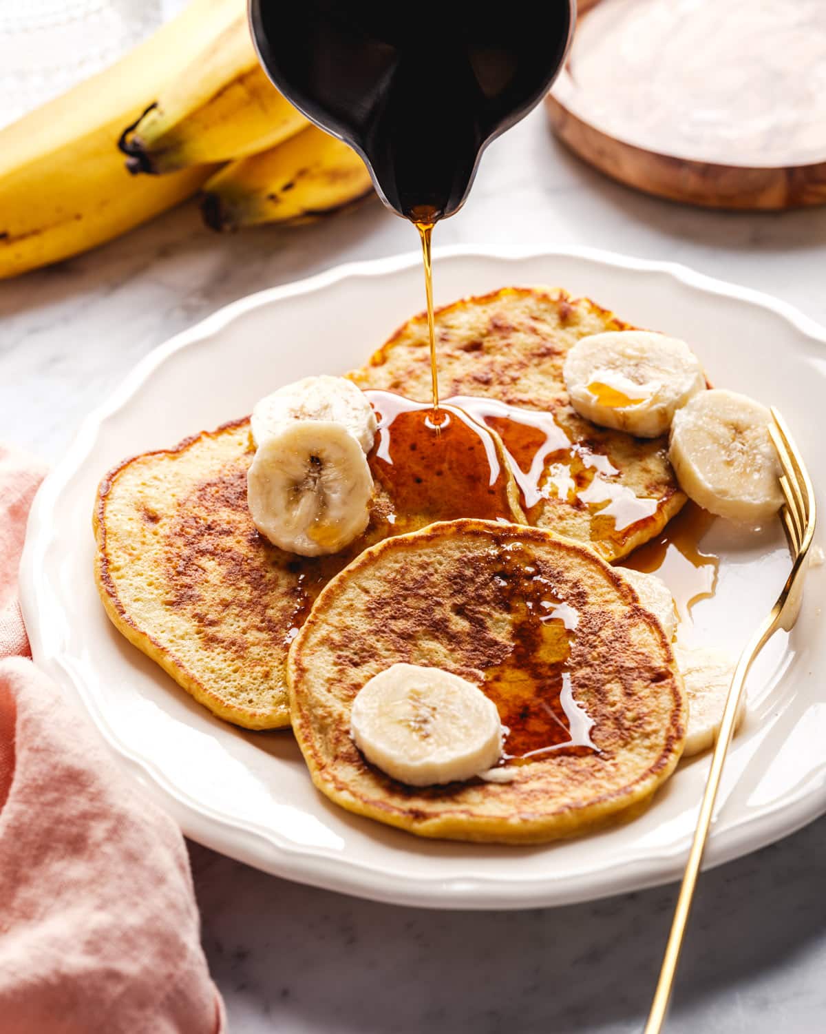 3 ingredient banana pancakes with maple syrup pouring on top.