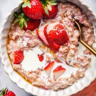 Strawberry Oatmeal in bowl with fresh strawberries.