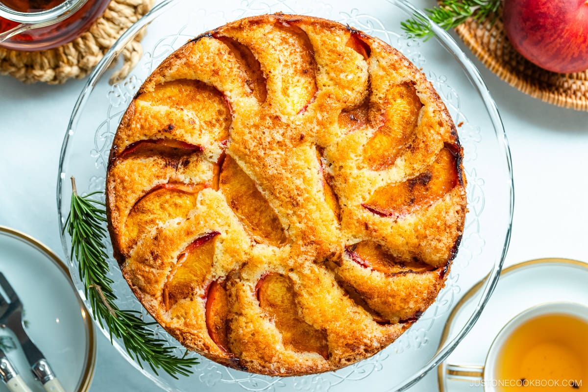 A whole Peach Cake on the glass cake stand.