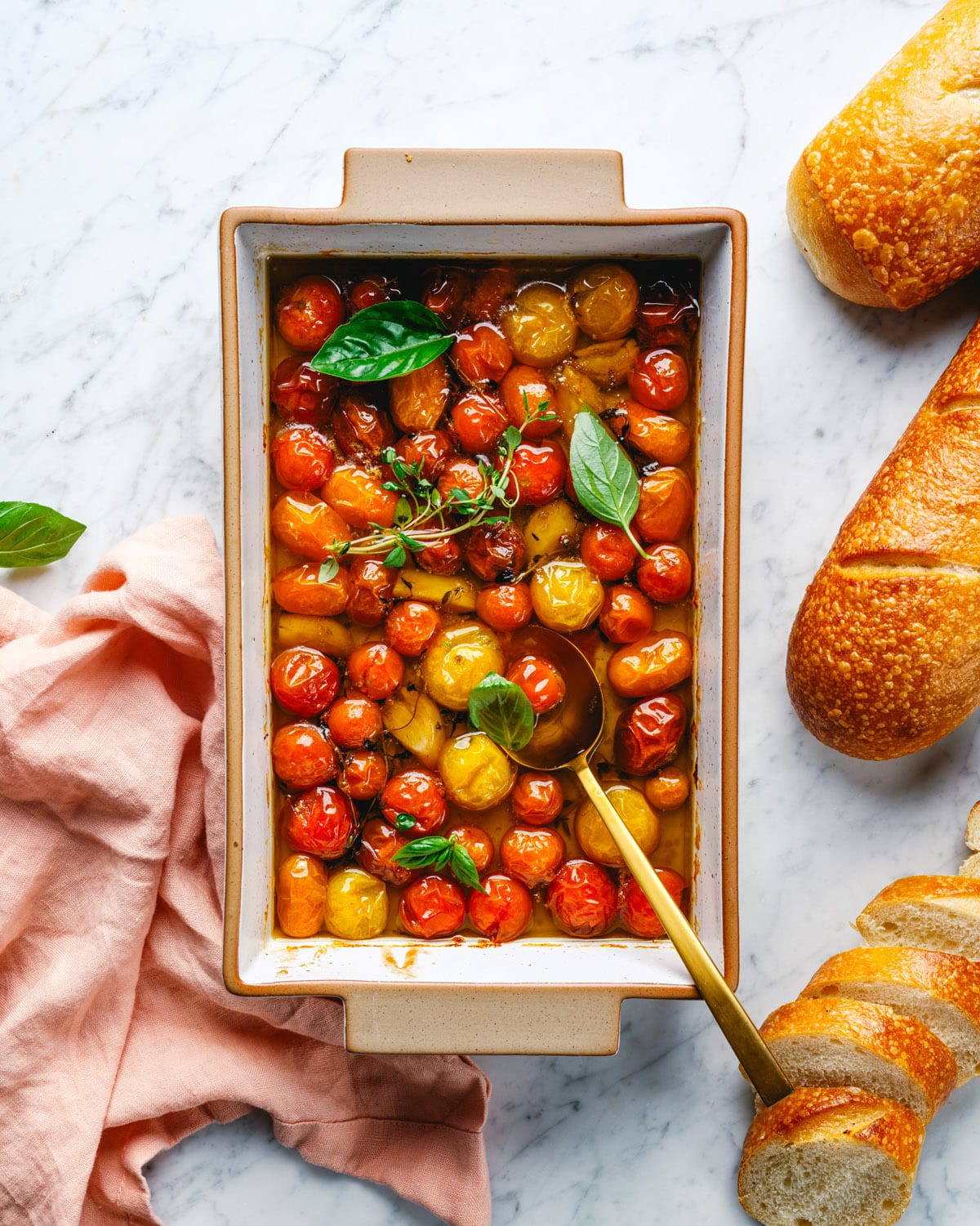 Tomato confit in pan with fresh herbs and bread. 