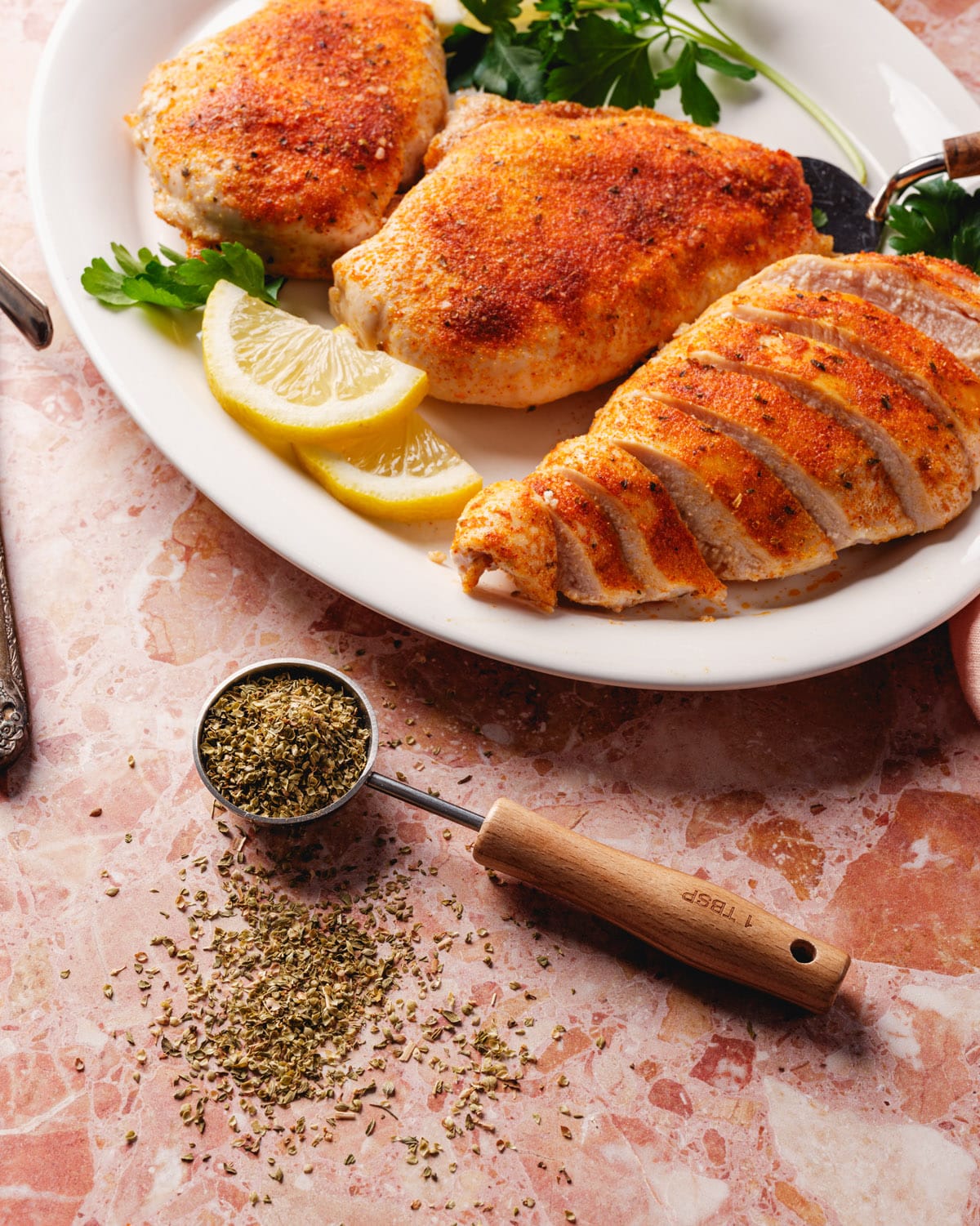 Oven baked chicken recipe on platter with dried oregano
