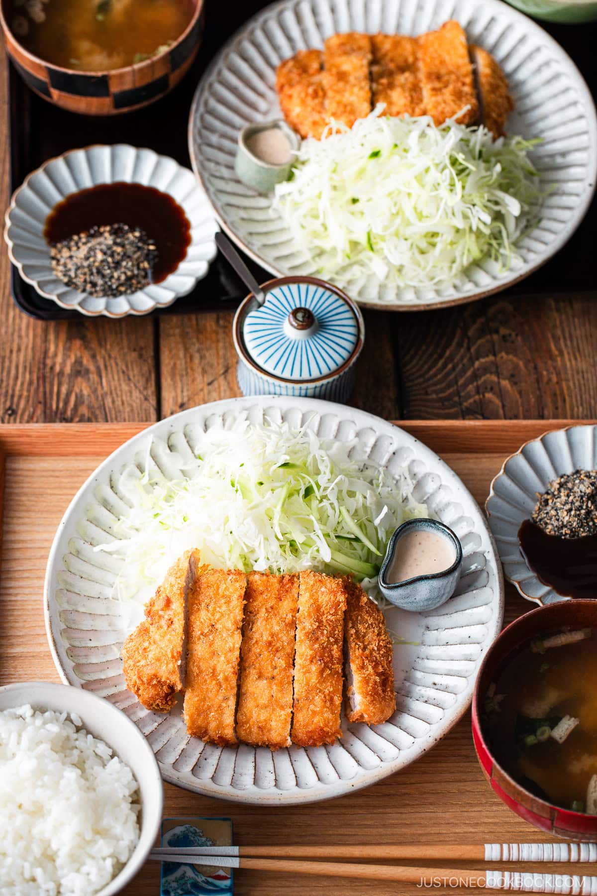 Japanese ceramic plates containing Tonkatsu (pork cutlet) and shredded cabbage salad.