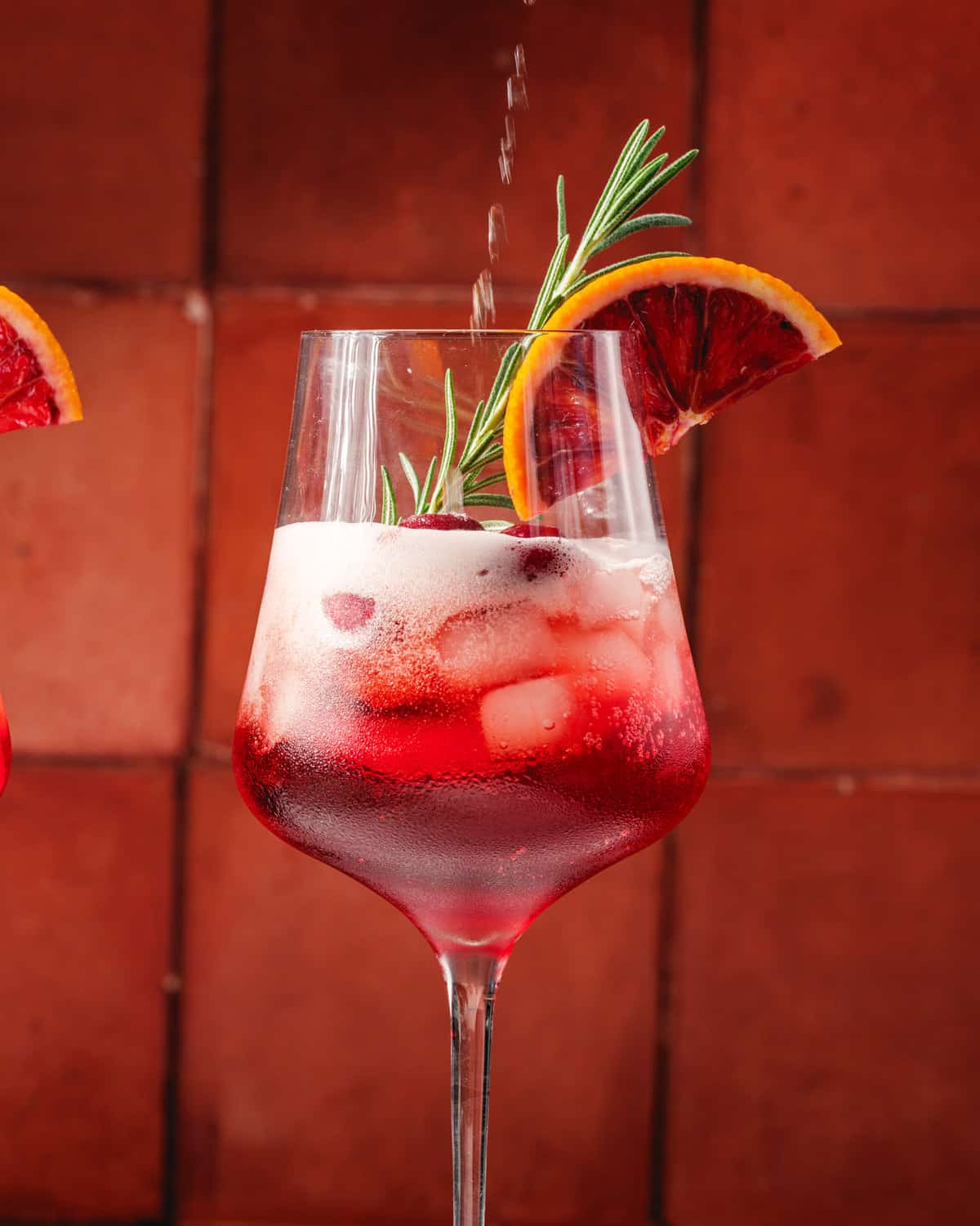 Cranberry Aperol Spritz with cranberries and rosemary garnish