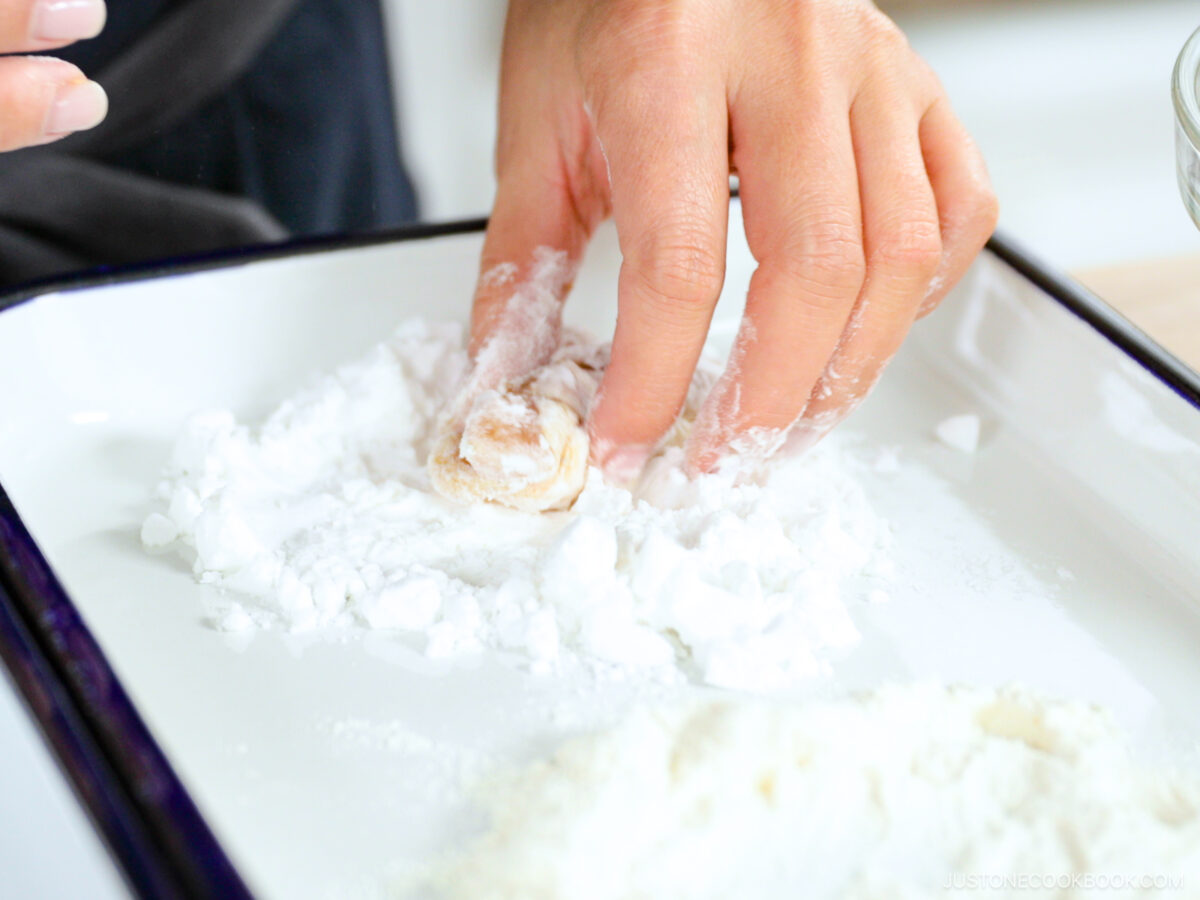 Dredging the chicken in the potato starch.