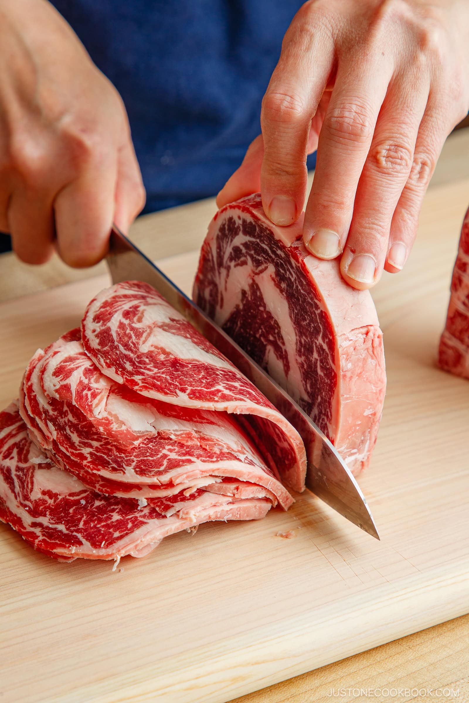 Slicing the block of the ribeye and filet mignon thinly.