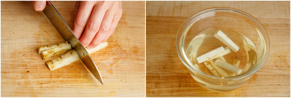 A hand slices burdock root on a wooden cutting board; beside it, cut burdock pieces soak in a glass bowl of water.